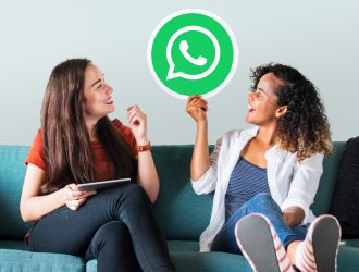 young women showing whatsapp messenger icon
